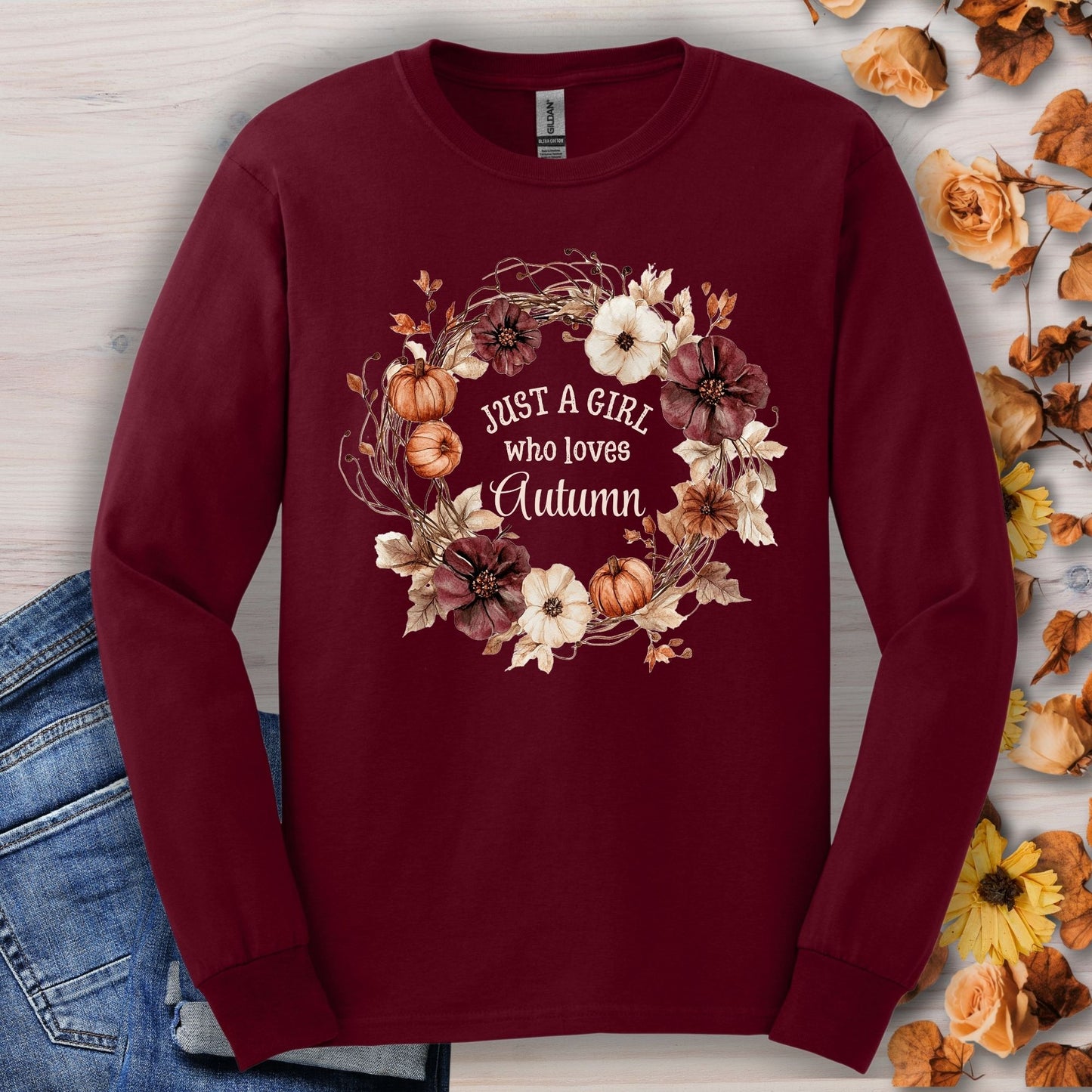 Maroon long sleeve tee with "Just a Girl who loves Autumn" in a watercolor pumpkin and flower wreath.
