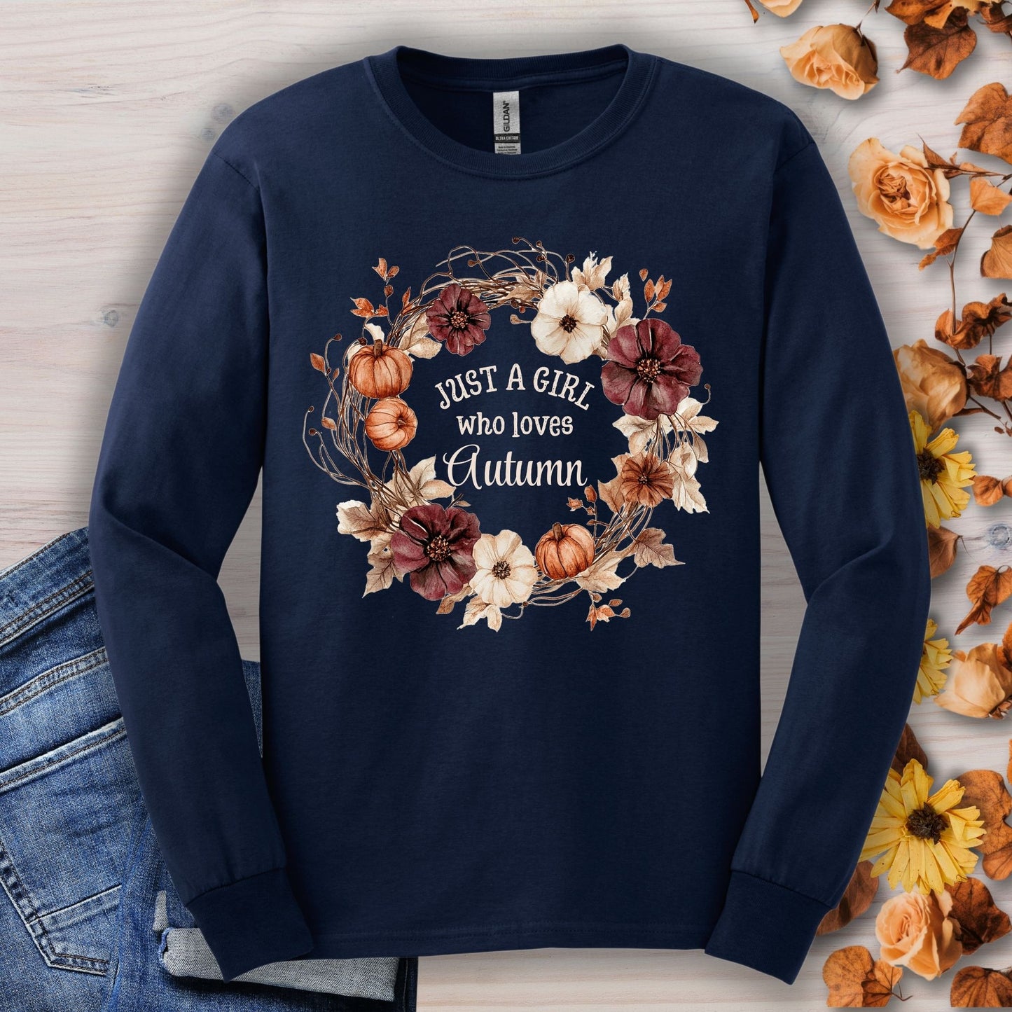 Navy long sleeve tee with a watercolor autumn wreath of pumpkins and flowers, "Just a Girl who loves Autumn" text.