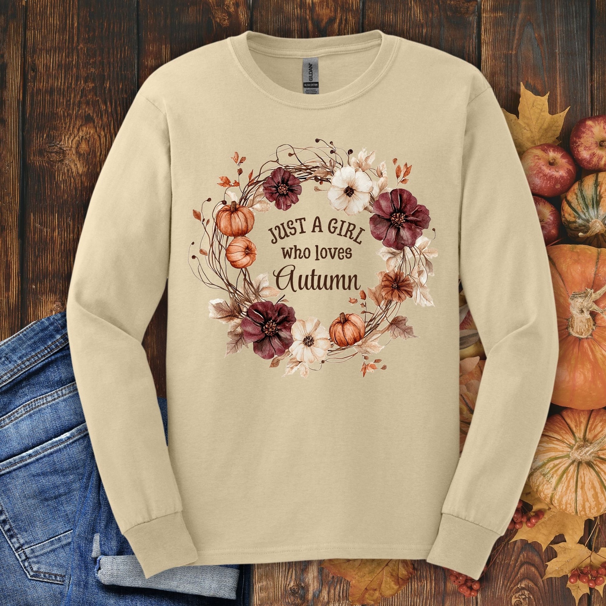 Sand Gildan long sleeve tee with "Just a Girl who loves Autumn" text and watercolor fall wreath design.