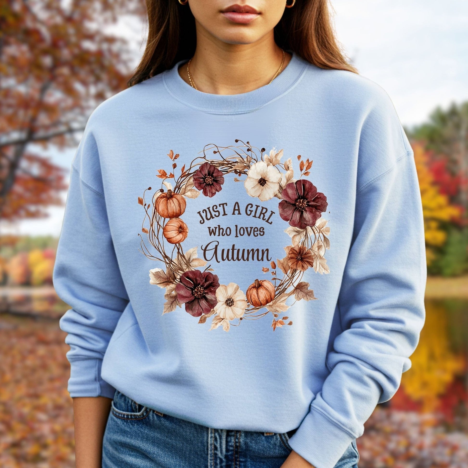 Light blue cotton-blend sweatshirt with "Just a Girl who loves Autumn" text in a watercolor floral wreath.