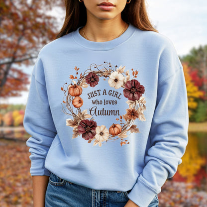 Light blue cotton-blend sweatshirt with "Just a Girl who loves Autumn" text in a watercolor floral wreath.