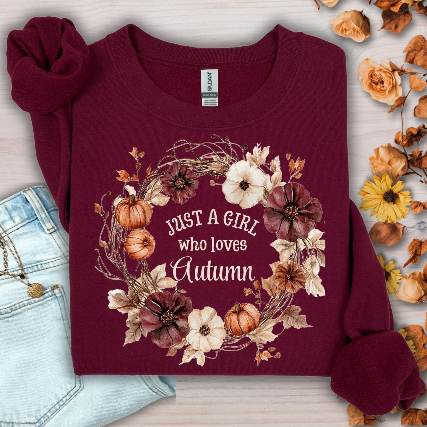 Maroon S sweatshirt with "Just a Girl who loves Autumn" text in a watercolor floral and pumpkin wreath.