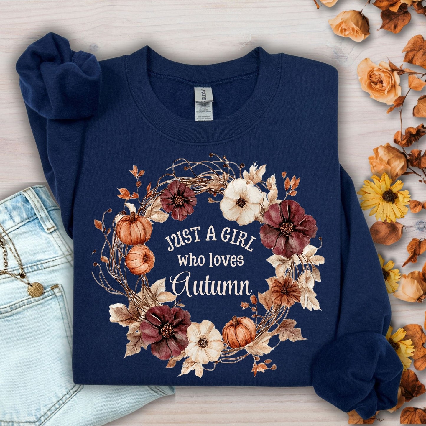 Navy "Just a Girl Who Loves Autumn" sweatshirt with watercolor fall wreath, pumpkins, and flowers.