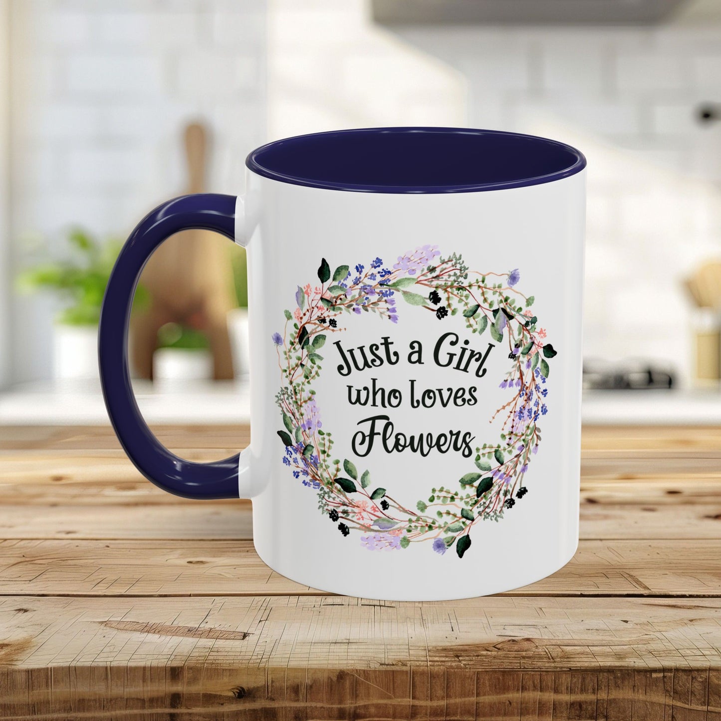 White ceramic mug with navy interior and handle, featuring a floral wreath and "Just a Girl who Loves Flowers" text.