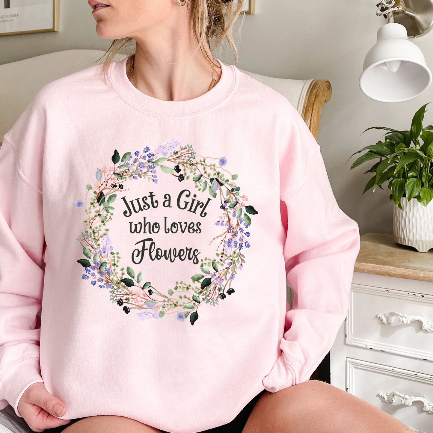 Pink crewneck sweatshirt with "Just a Girl who loves Flowers" in a delicate floral wreath design.