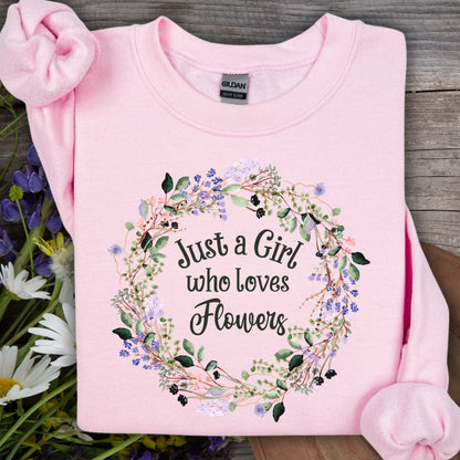 Light pink crewneck sweatshirt with "Just a Girl who loves Flowers" in a delicate floral wreath design.