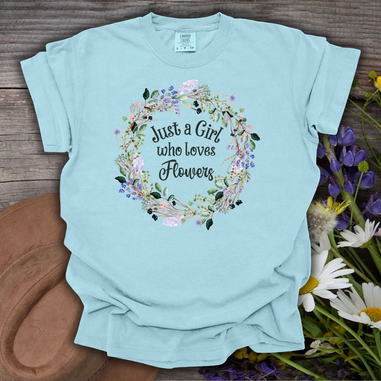 Light blue garment-dyed cotton t-shirt with "Just a Girl who loves Flowers" in a watercolor floral wreath.