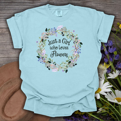 Light blue garment-dyed cotton t-shirt with "Just a Girl who loves Flowers" in a watercolor floral wreath.