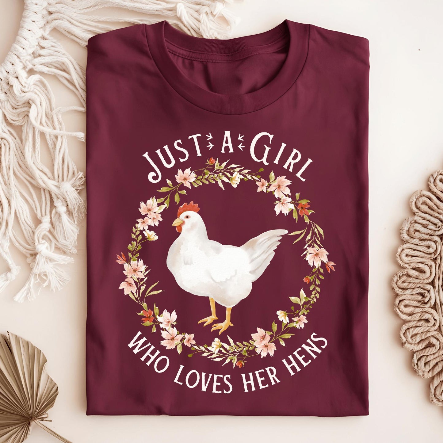 Maroon heavyweight cotton "Just a Girl Who Loves Her Hens" t-shirt with a white hen and floral wreath design.