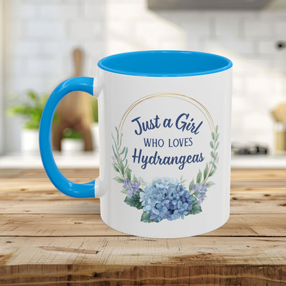 White ceramic mug with blue interior and handle, featuring a watercolor hydrangea wreath and "Just a Girl Who Loves Hydrangeas" text.