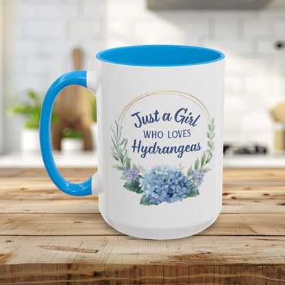 White ceramic mug with blue interior and handle, featuring a watercolor hydrangea wreath and "Just a Girl Who Loves Hydrangeas" text.