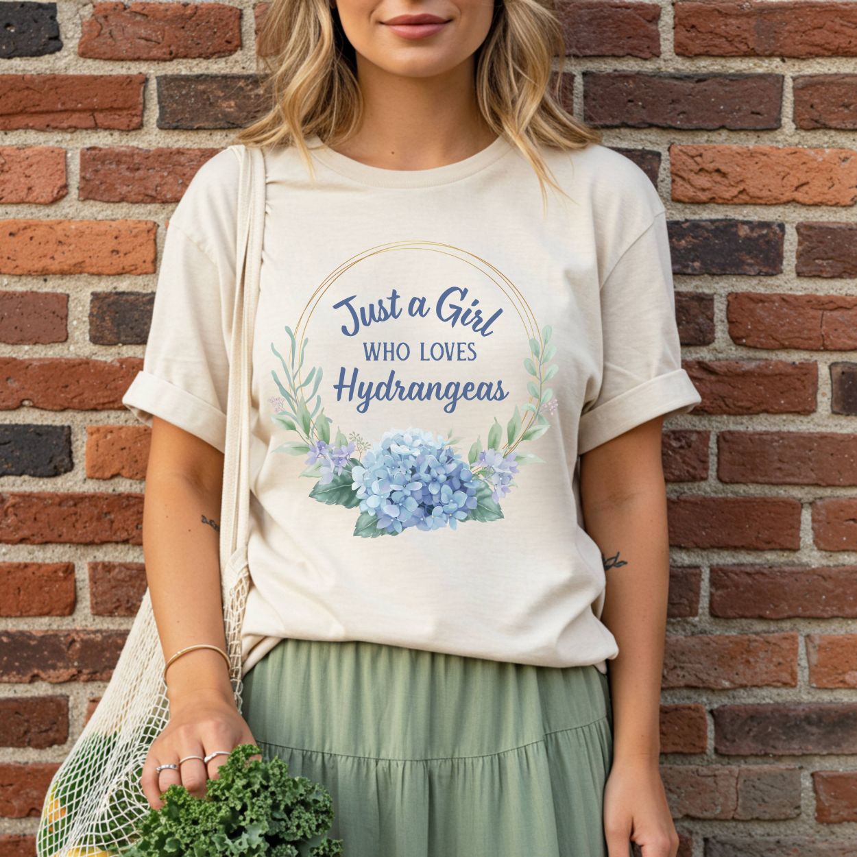 Relaxed-fit, garment-dyed cream t-shirt with "Just a Girl Who Loves Hydrangeas" text and a watercolor blue hydrangea design.