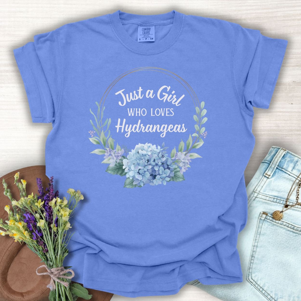 Periwinkle garment-dyed cotton t-shirt with "Just a Girl Who Loves Hydrangeas" and watercolor hydrangeas.