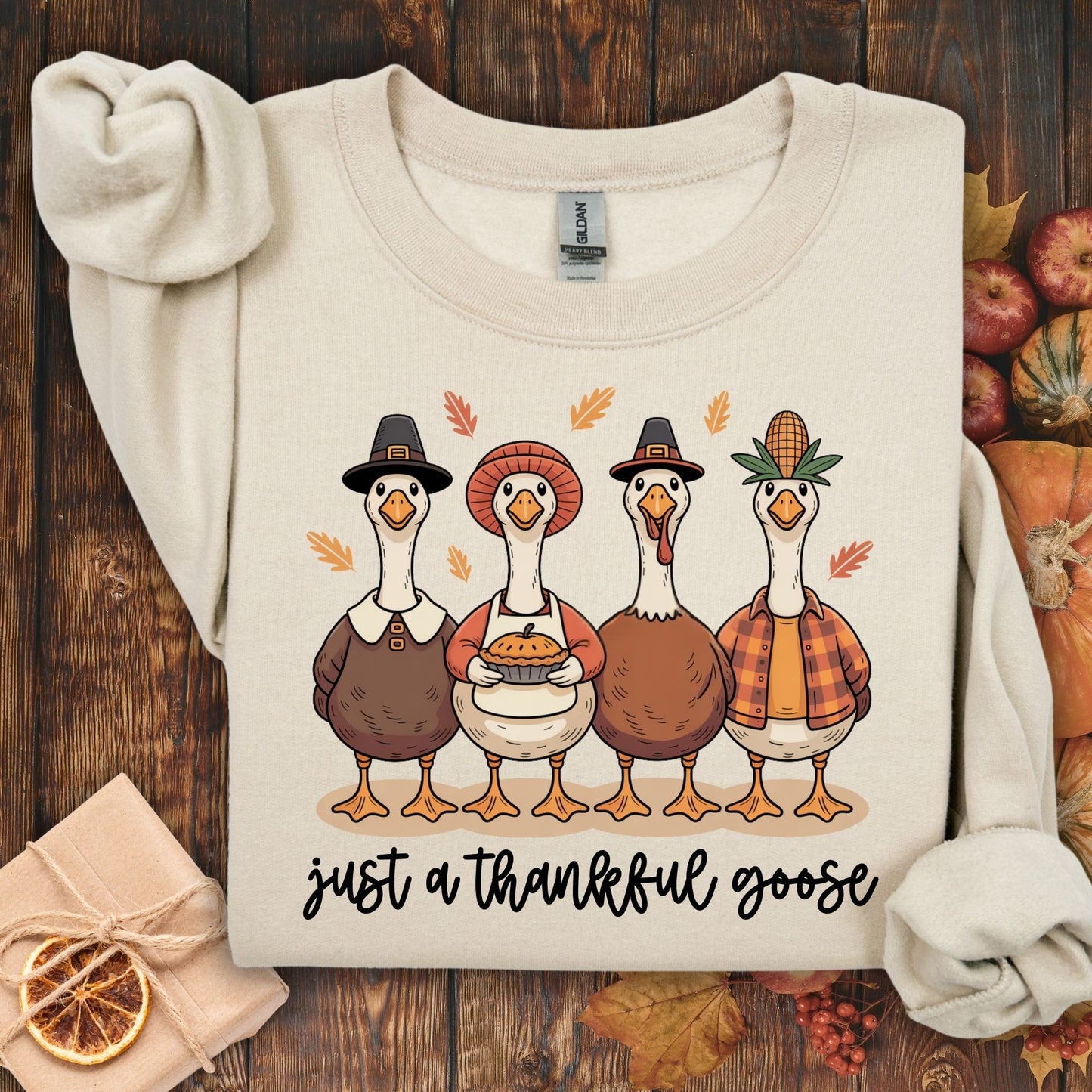 Sand S heavy blend sweatshirt with "Just a Thankful Goose" and pilgrim ducks enjoying apple pie.