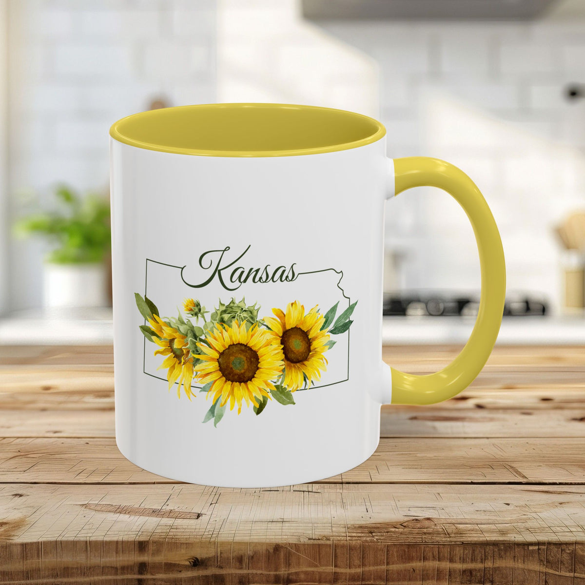 White 11oz ceramic mug with yellow handle and interior, featuring a watercolor Kansas state outline with sunflowers.
