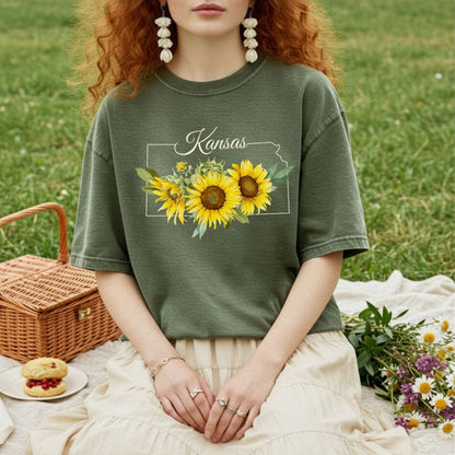 Garment-dyed olive green t-shirt with a Kansas state outline and golden sunflower graphic.