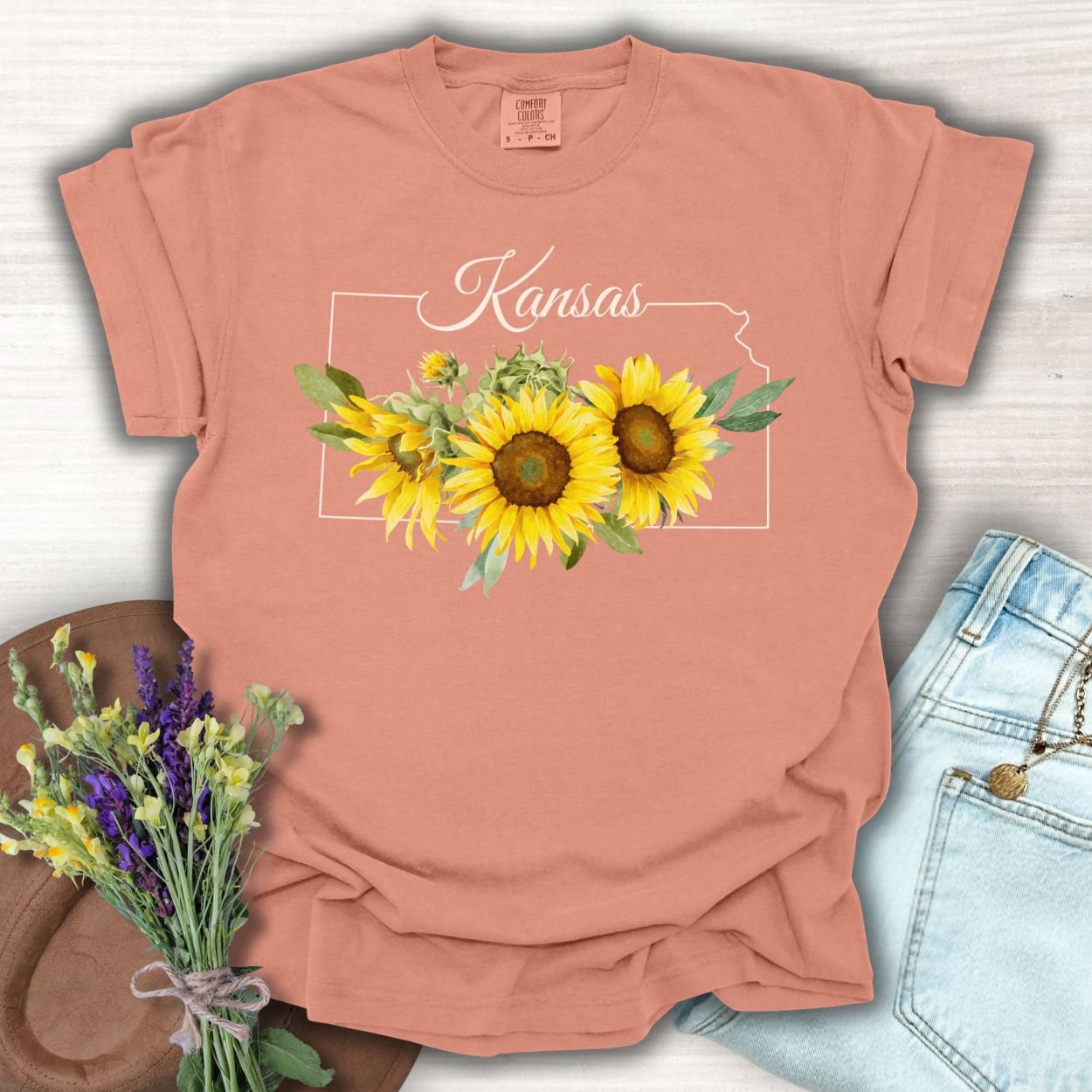 Terracotta S-size t-shirt with a Kansas state outline and golden sunflowers.