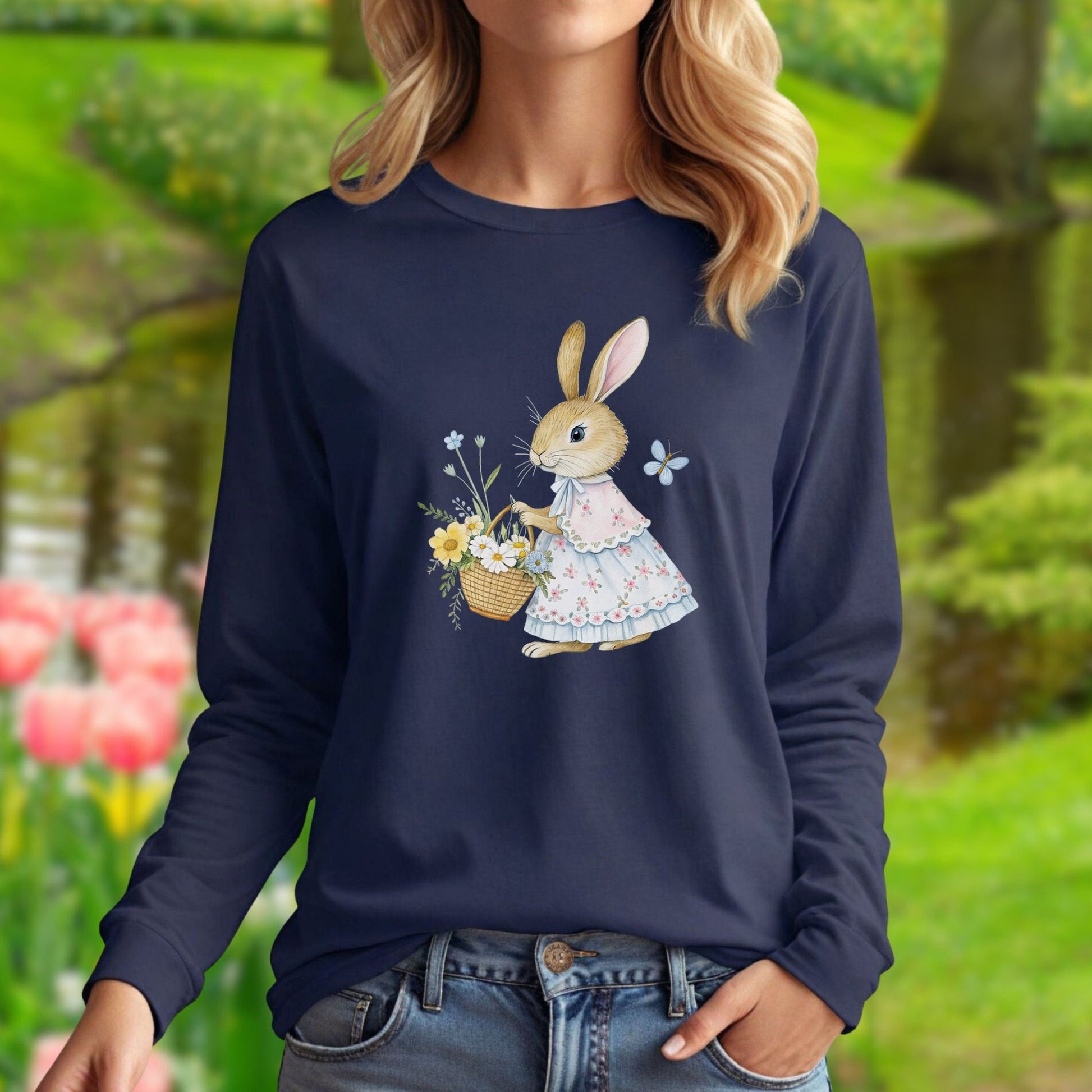 Woman in navy long sleeve tee with a watercolor lady bunny in a floral dress holding a spring flower basket.