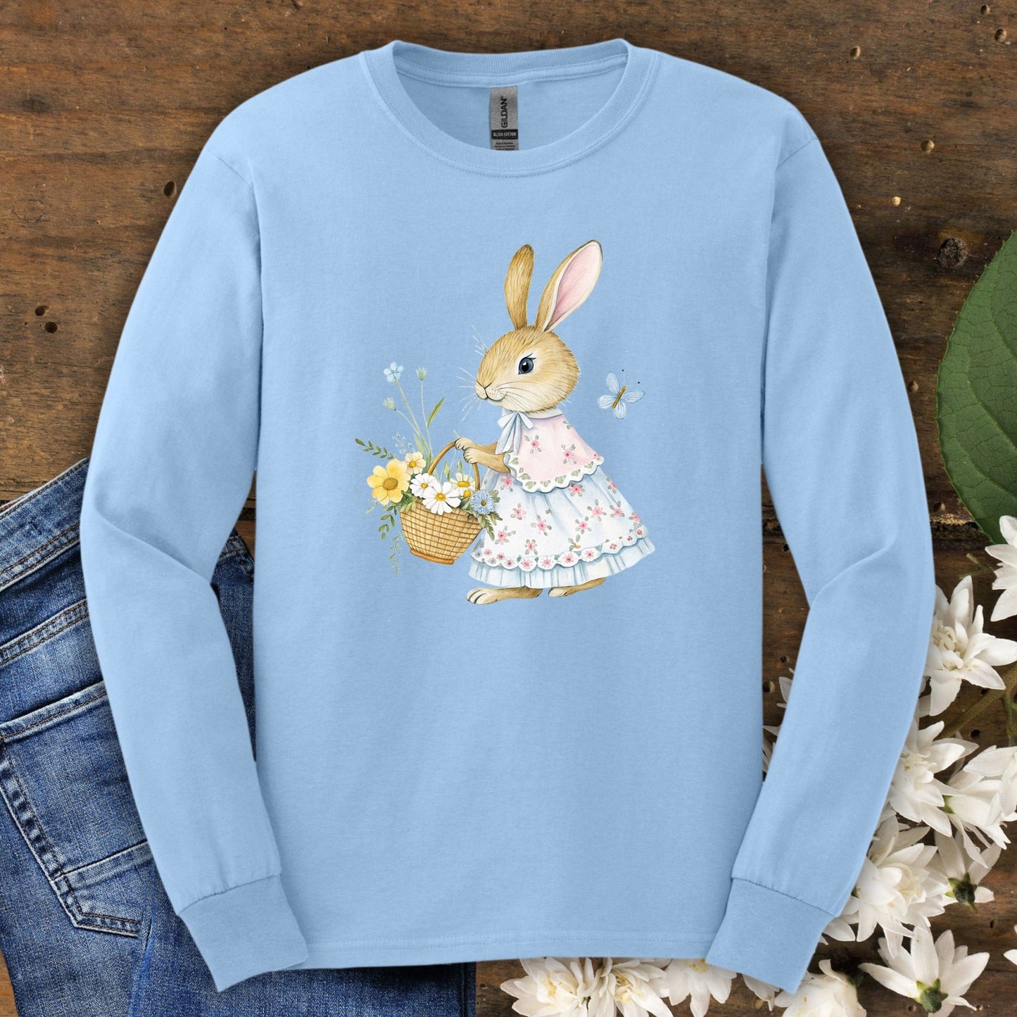 Light blue long sleeve tee with a watercolor lady bunny in a floral dress holding a flower basket.