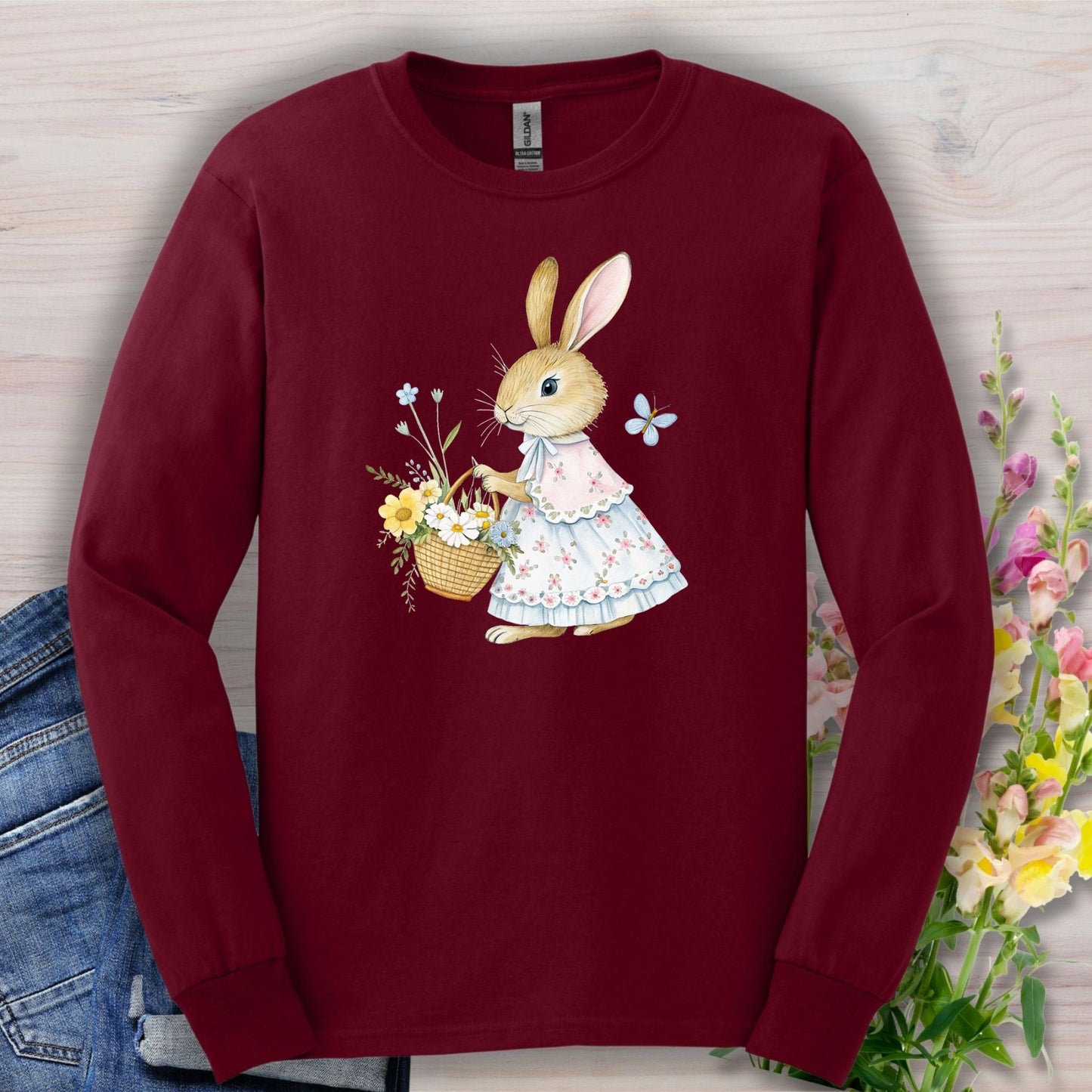 Maroon long-sleeve tee with a watercolor lady bunny in a floral dress holding a flower basket.
