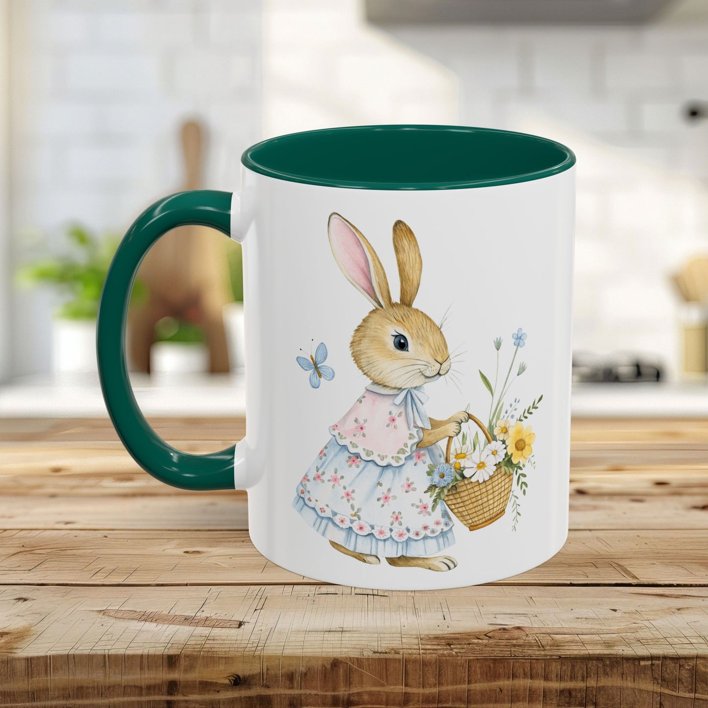 White ceramic mug with a green handle and interior, featuring a watercolor bunny in a dress holding a flower basket.