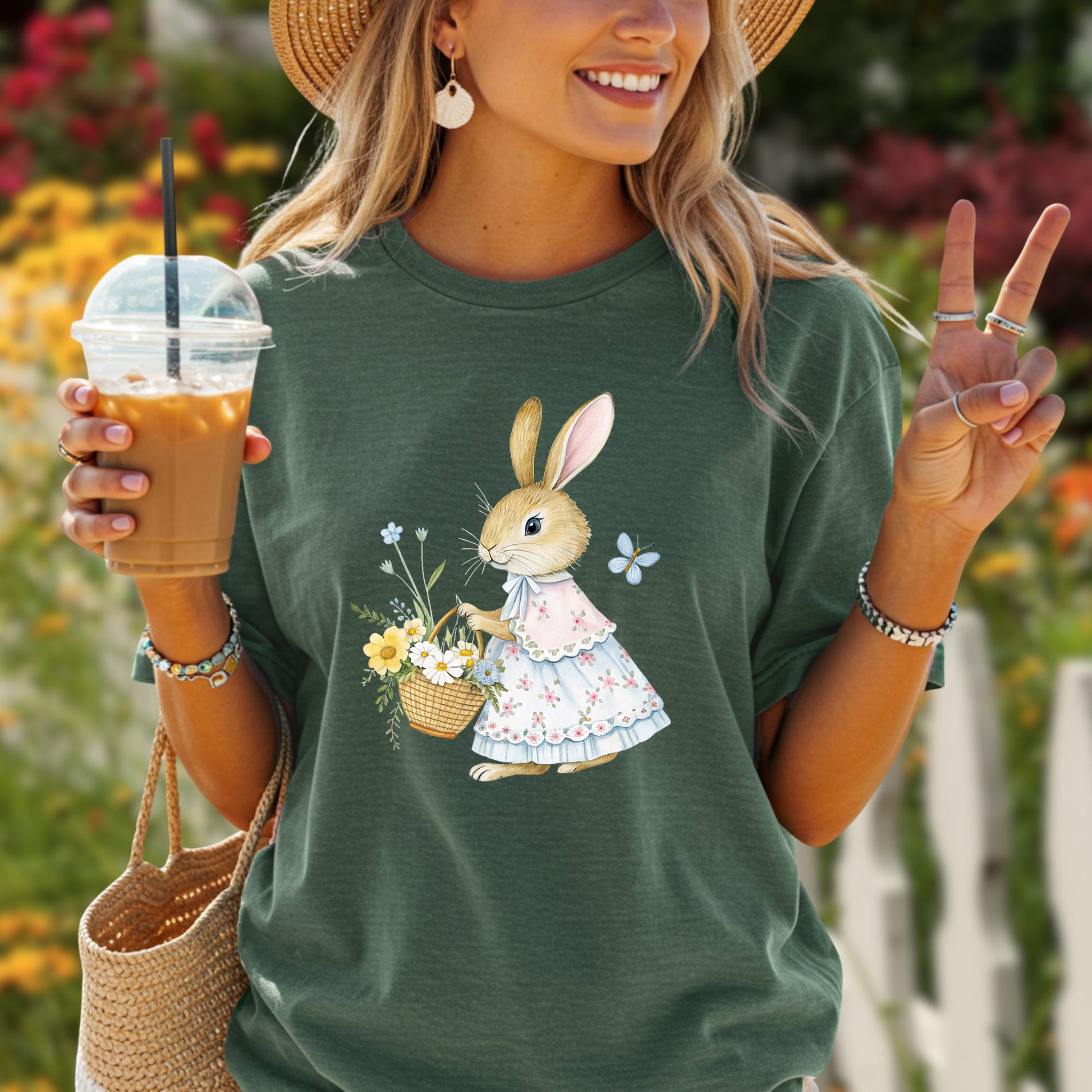 Relaxed-fit, garment-dyed green t-shirt with a watercolor bunny in a floral dress holding a flower basket.