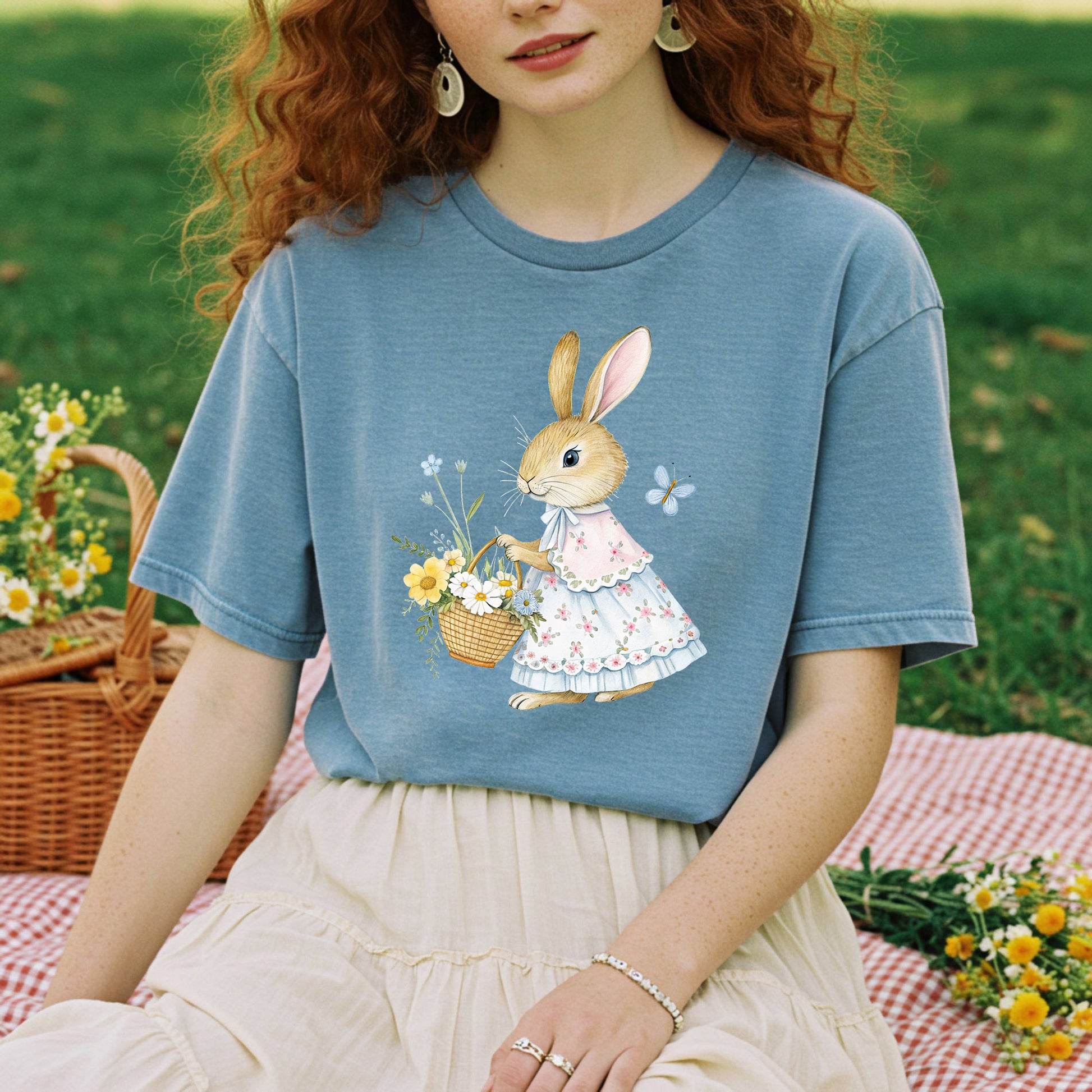 Garment-dyed blue cotton t-shirt with a watercolor bunny in a floral dress holding a flower basket.