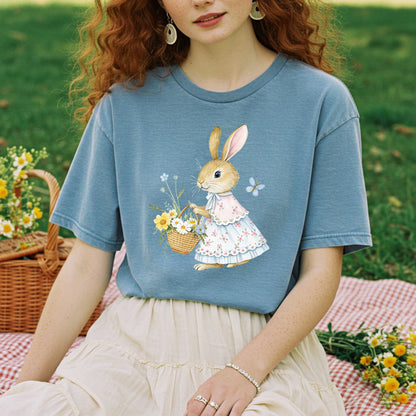 Garment-dyed blue cotton t-shirt with a watercolor bunny in a floral dress holding a flower basket.