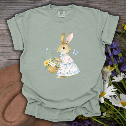 Bay green garment-dyed cotton t-shirt with a watercolor bunny in a floral dress holding a flower basket.