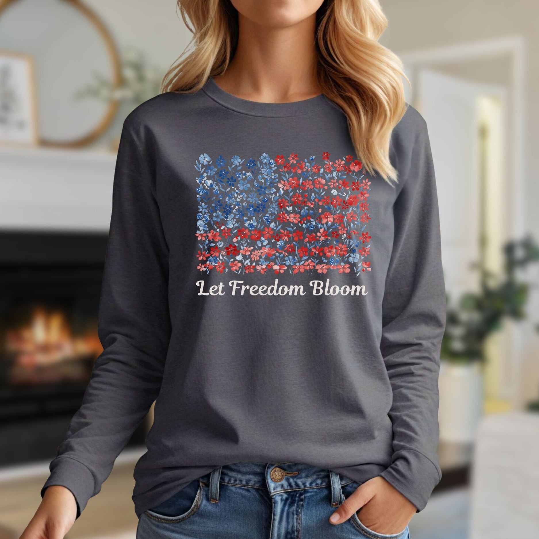 Woman in a charcoal long sleeve tee with a faded floral American flag graphic and "Let Freedom Bloom" text.