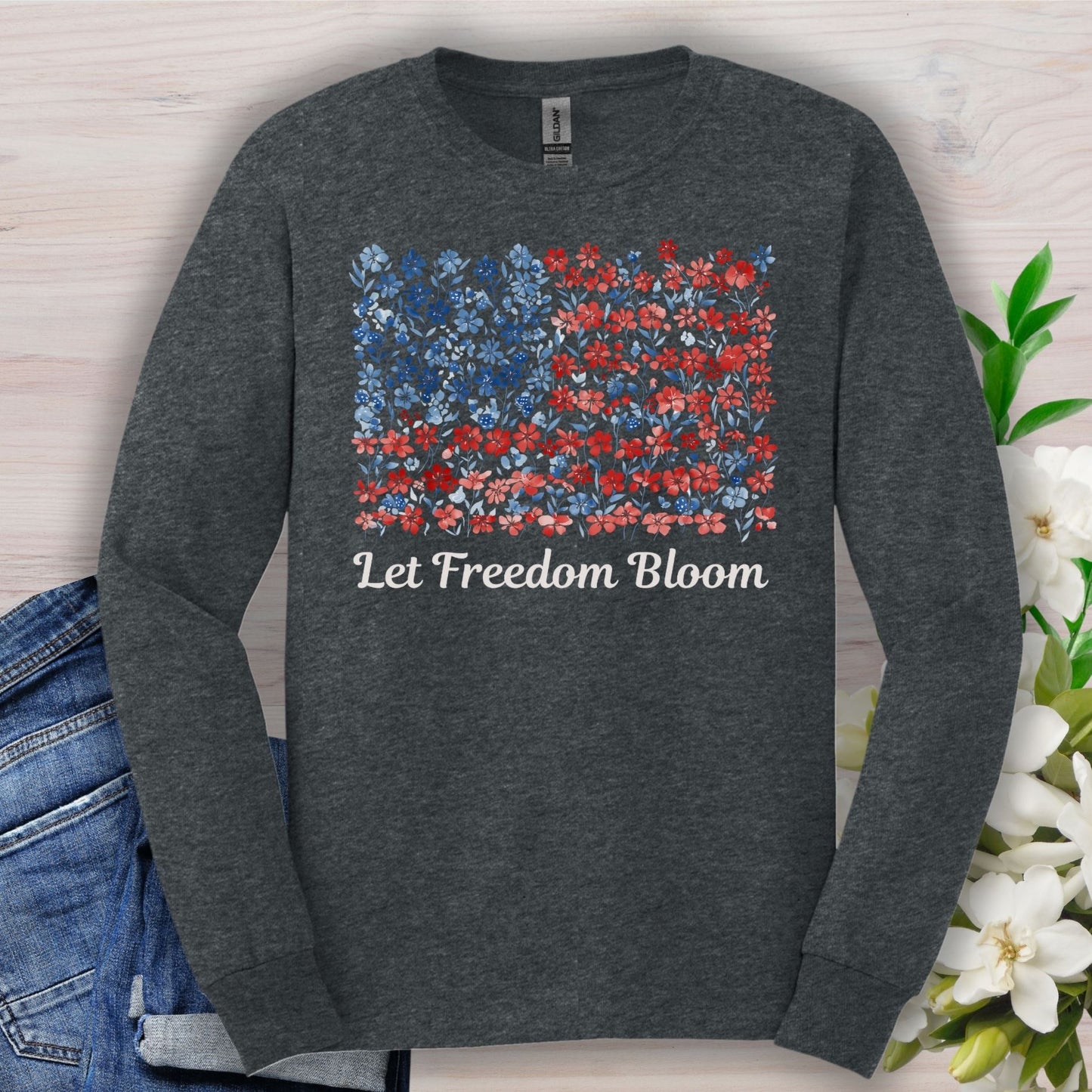 Dark Heather long sleeve tee with a faded floral American flag graphic and "Let Freedom Bloom" text.