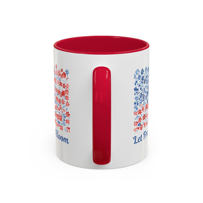 White ceramic mug with red interior and handle, featuring a floral flag design and "Let Freedom Bloom" text.