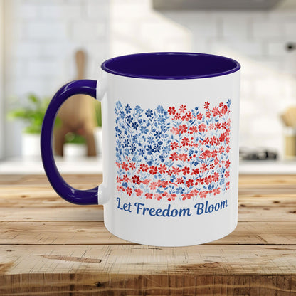 White ceramic mug with a navy handle and interior, featuring a floral flag design and "Let Freedom Bloom.