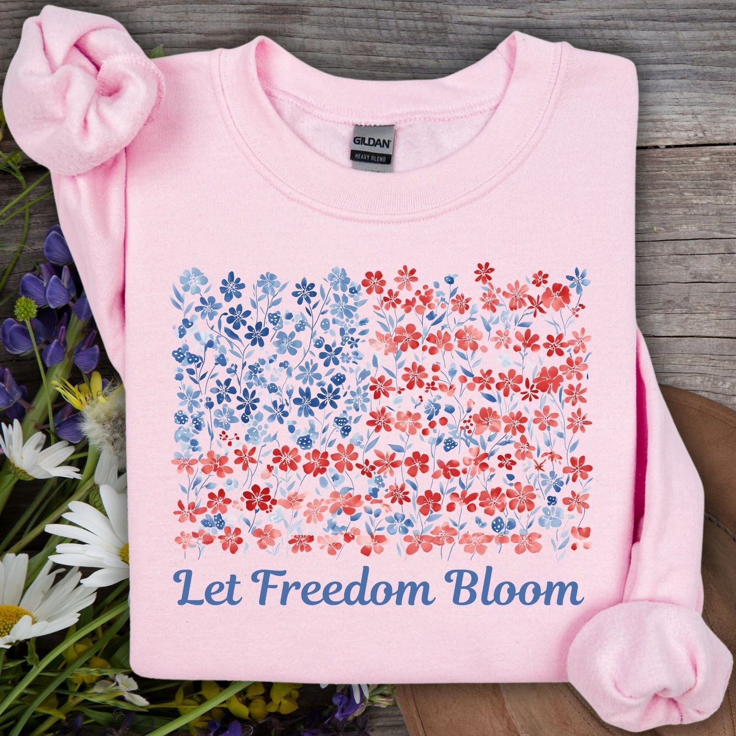 Light pink crewneck sweatshirt with a floral flag design and "Let Freedom Bloom" text.