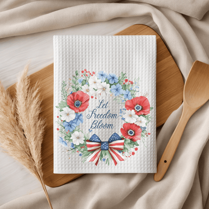 White microfiber tea towel with "Let Freedom Bloom" in a patriotic floral wreath and American flag bow.