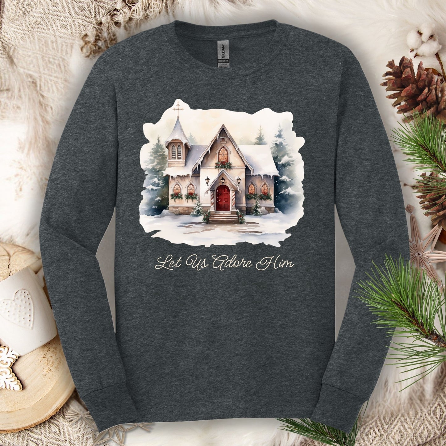 Dark Heather long sleeve tee with watercolor snow-covered chapel and "Let Us Adore Him" text.