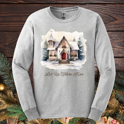 Ash grey long sleeve tee with a watercolor snow-covered country chapel and "Let Us Adore Him" text.