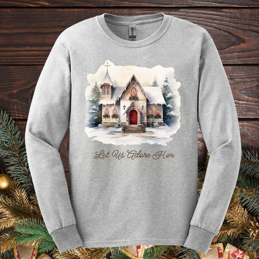 Ash grey long sleeve tee with a watercolor snow-covered country chapel and "Let Us Adore Him" text.