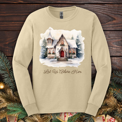 Sand long sleeve tee with a watercolor snow-covered chapel and "Let Us Adore Him" text.