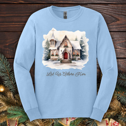 Light blue long sleeve tee with a watercolor snow-covered country chapel and "Let Us Adore Him" text.