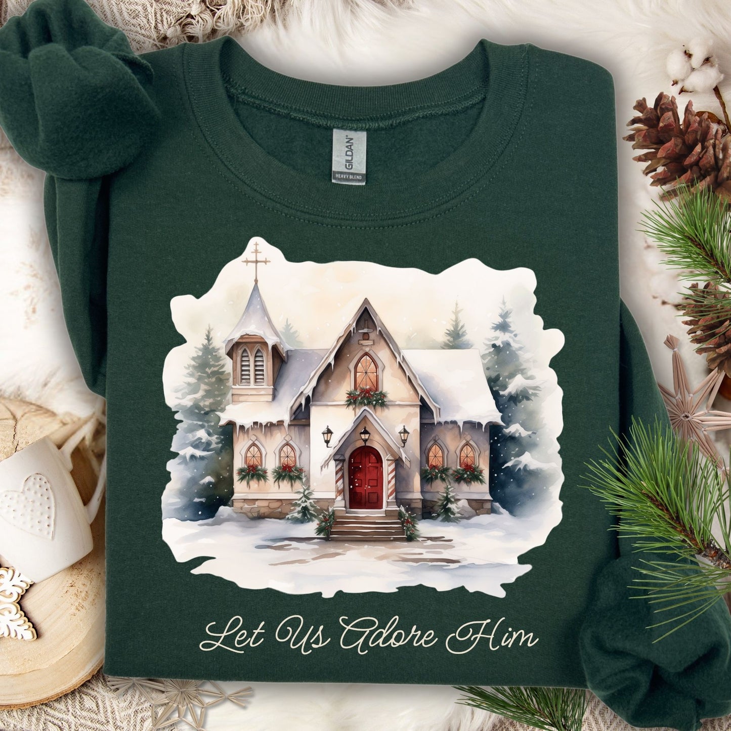 Forest Green Gildan sweatshirt with a snowy country chapel design and "Let Us Adore Him" text.
