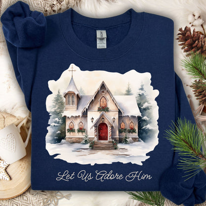 Navy Gildan fleece sweatshirt with a snowy country chapel and "Let Us Adore Him" text.