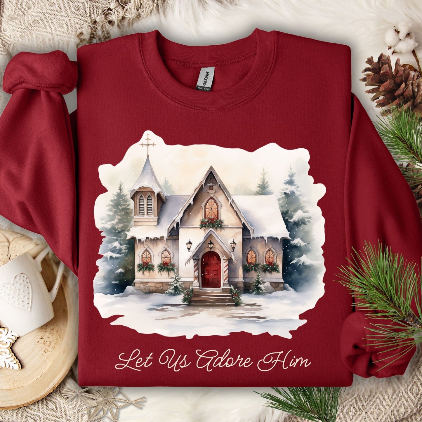 Cardinal Red Gildan sweatshirt with a snowy chapel design and "Let Us Adore Him" text.