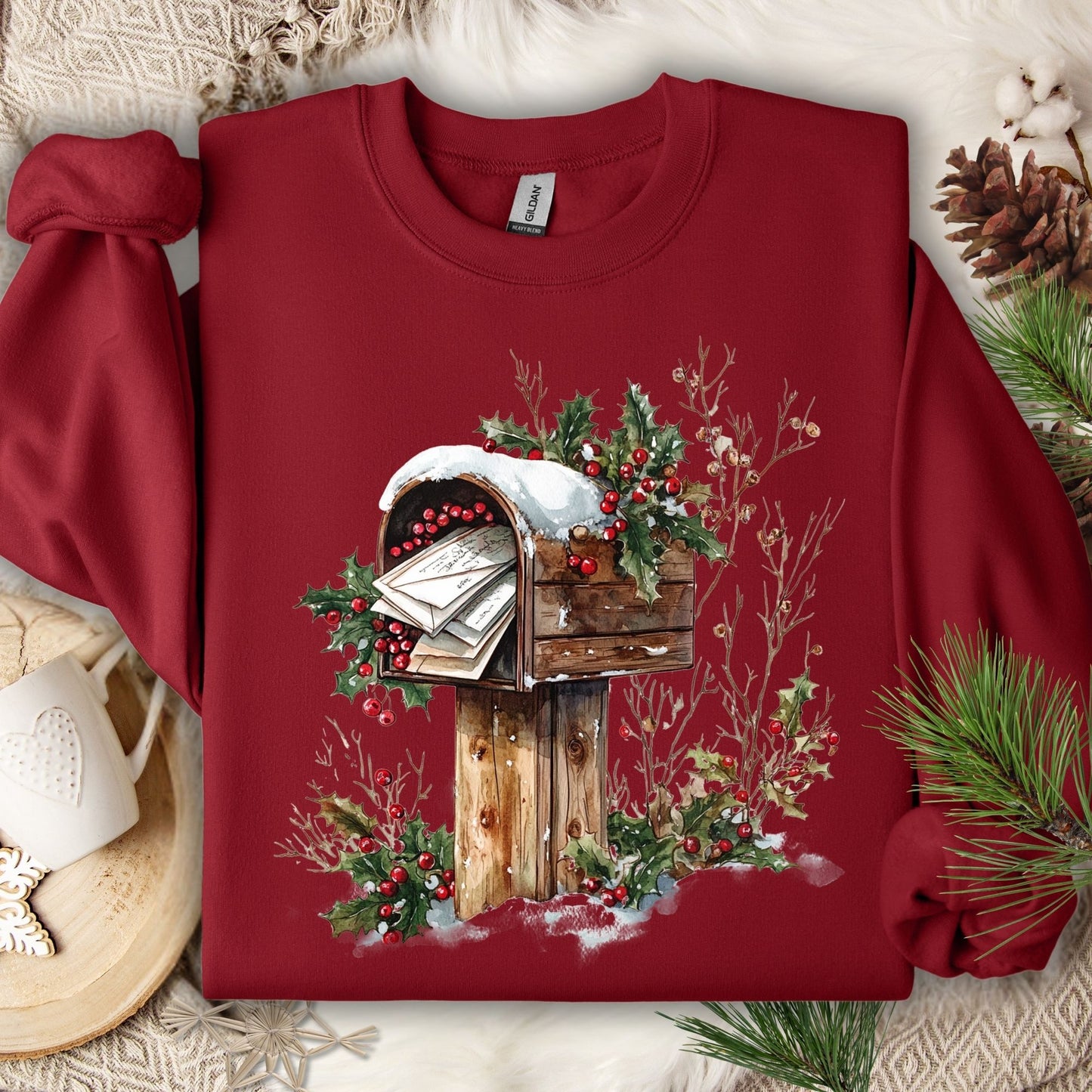Cardinal Red Gildan sweatshirt with a watercolor rustic wooden mailbox, snow, and holly berries design.