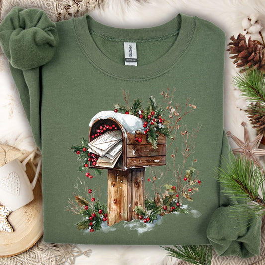 Military Green Gildan sweatshirt with a watercolor rustic mailbox, snow, and holly berries design.
