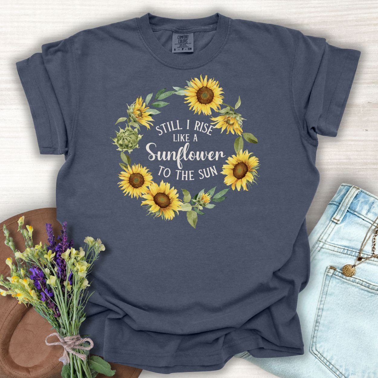 Denim S t-shirt with "Still I Rise Like a Sunflower to the Sun" in a sunflower wreath.