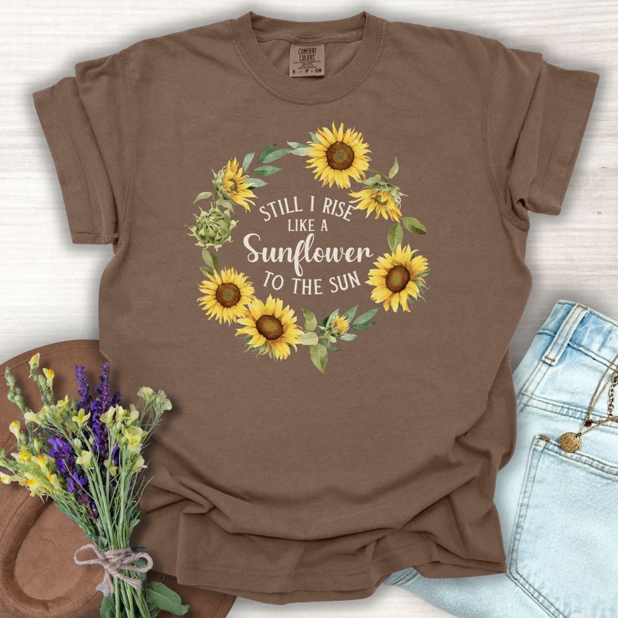 Espresso S-sized cotton t-shirt with a sunflower wreath and "Still I Rise Like a Sunflower to the Sun" text.