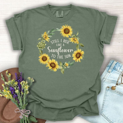 Moss green cotton t-shirt with a sunflower wreath and "Still I Rise Like a Sunflower to the Sun" text.