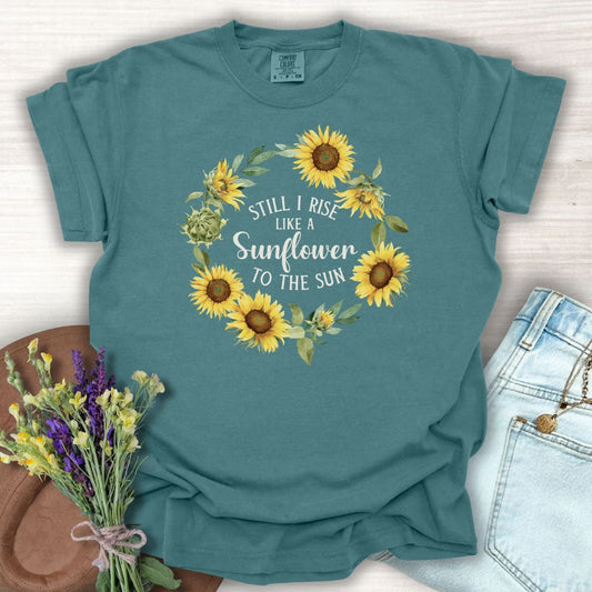 Blue Spruce cotton t-shirt with "Still I Rise Like a Sunflower to the Sun" in a sunflower wreath.