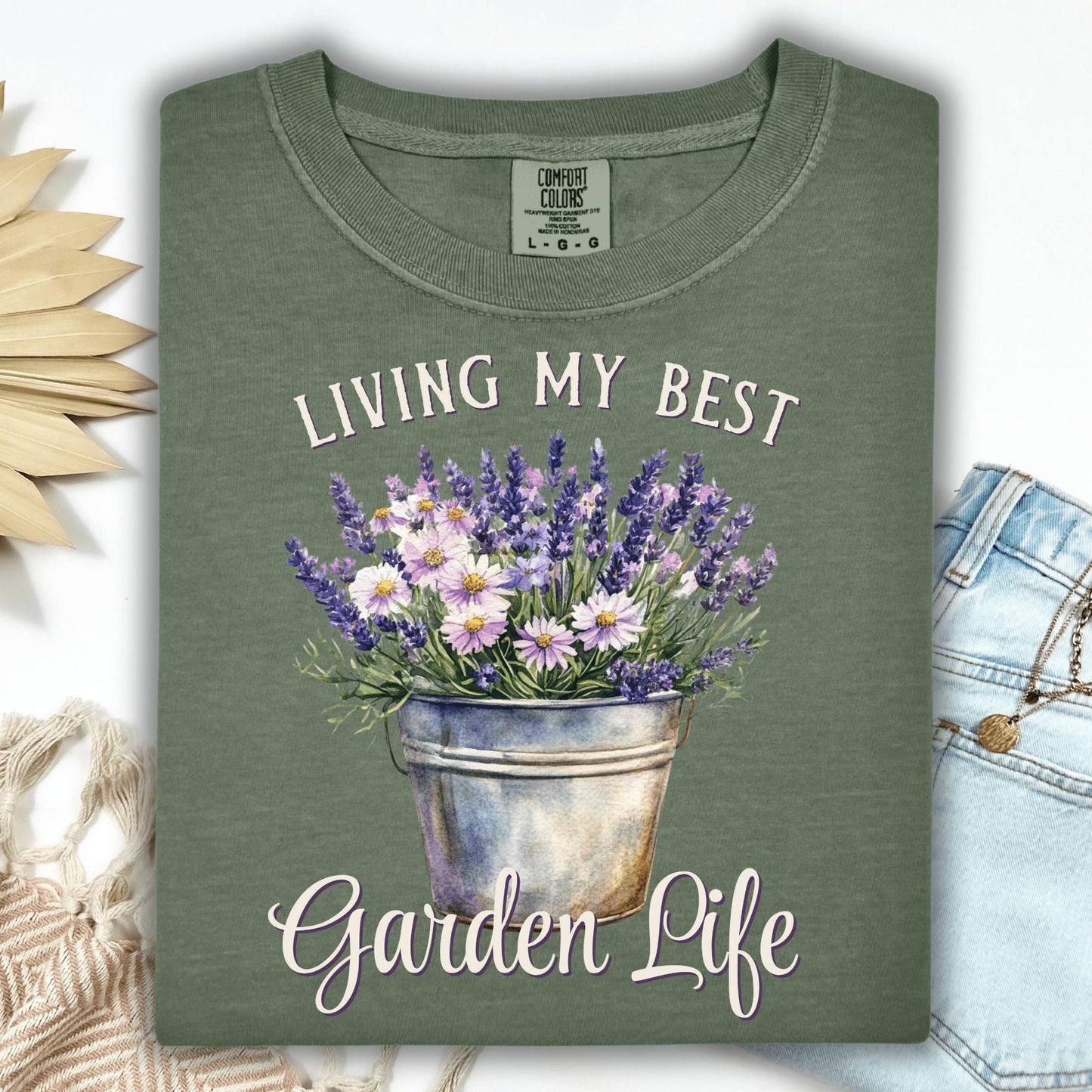 Moss green "Living My Best Garden Life" t-shirt with a lavender and daisy bucket graphic.